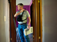 An inspector standing in doorway with a clipboard