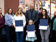 Four kids holding their Rising Stars award, pose with City Council members.